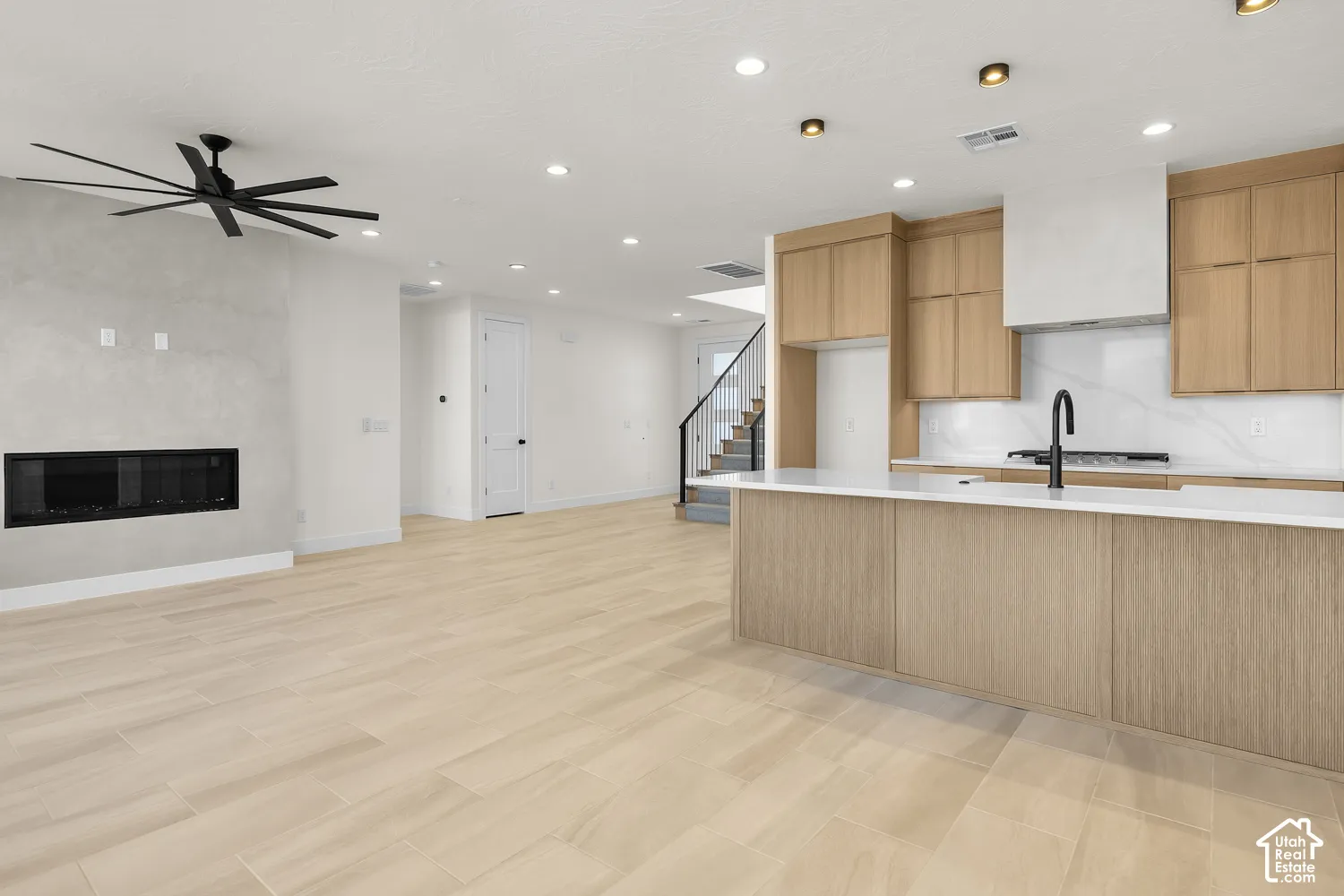 Open-concept living space with light-toned wood-finish flooring