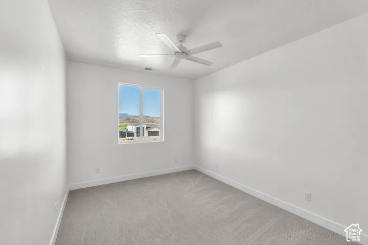 Recessed window with clear insulated glass, a white ceiling fan, and light neutral-toned carpeting