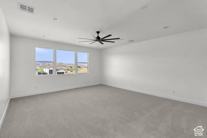 Spacious room featuring three large windows, recessed lighting, and a ceiling fan