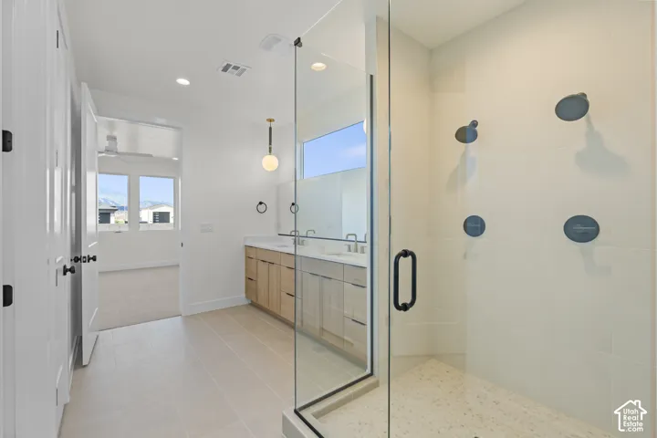 Large glass-enclosed shower with multiple matte black shower heads