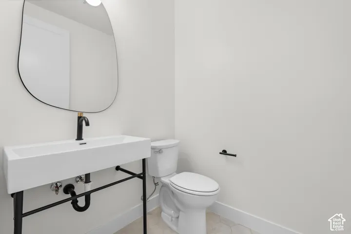 Modern vanity with a rectangular basin, matte black faucet, and an organically shaped mirror