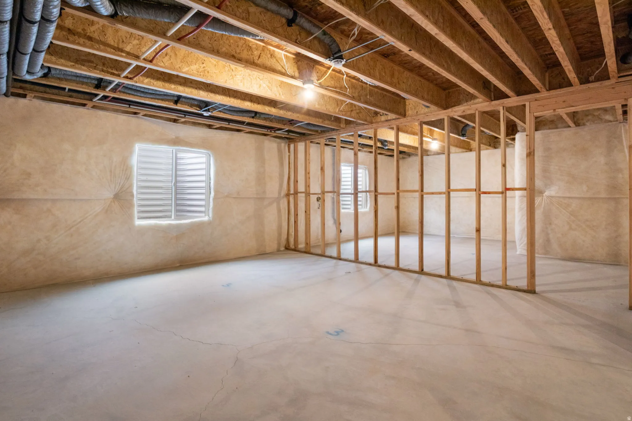 Large unfinished basement featuring several framed walls to make your own.