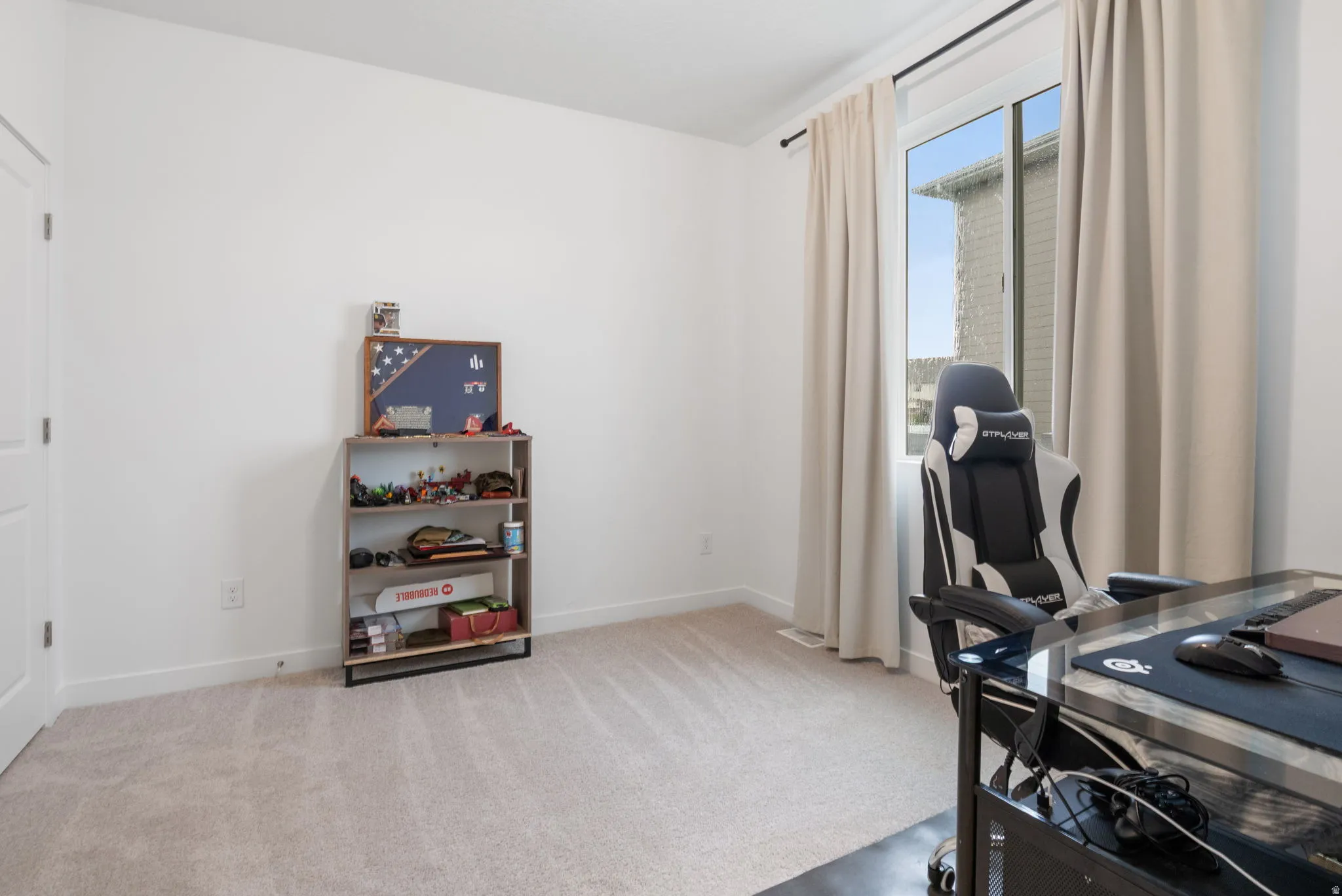3rd bedroom can be used as an office. light carpeted flooring, and a large window with drapes