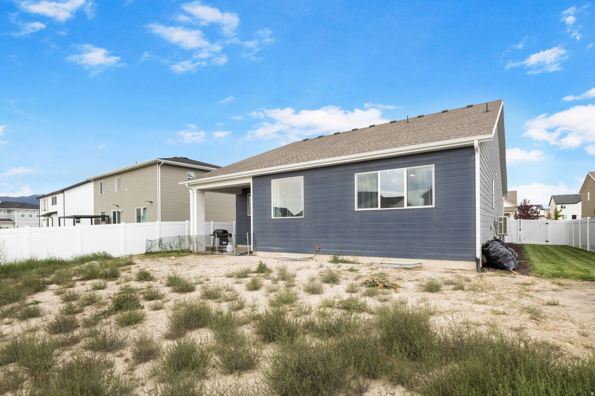 Rear exterior showcasing fully fenced yard side yards are grassed but entire yard will be grassed.