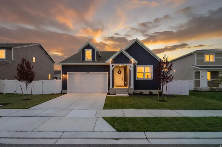 Contemporary exterior with dark siding and white trim, long driveway and gable roof