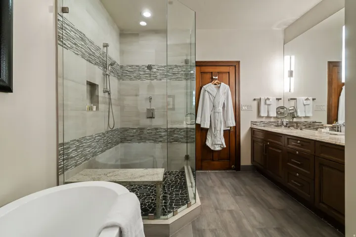 Glass-enclosed shower with a built-in bench and pebble tile floor