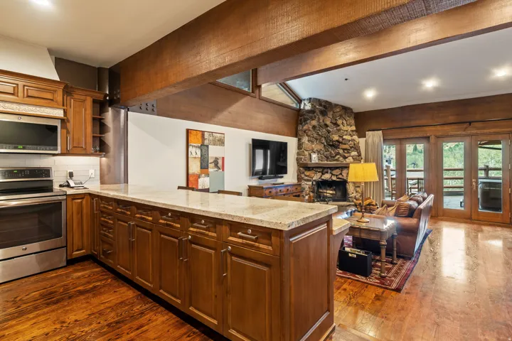 Kitchen with wood-finish flooring, stainless steel appliances, and a light-toned countertop