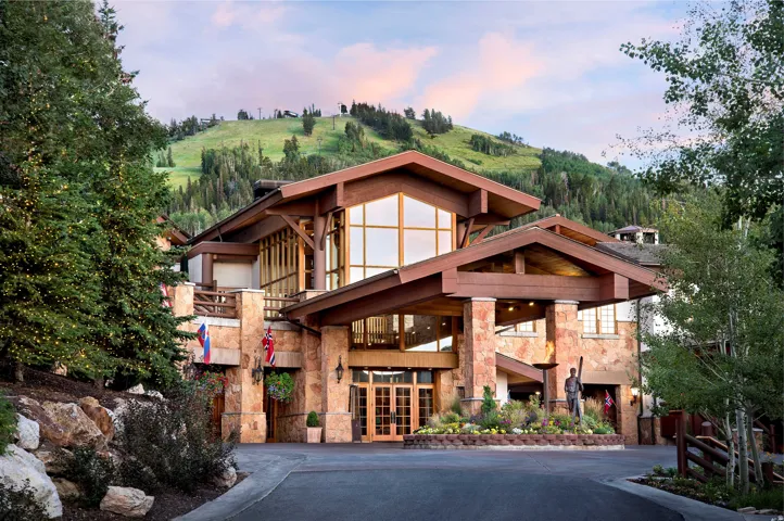 Stone and timber lodge-style architecture with expansive windows and a covered entrance