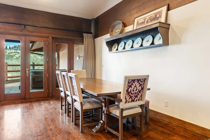 Wood-finish flooring, wood-frame glass doors, and a built-in wall shelf