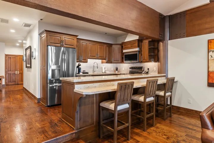 Gourmet kitchen featuring rich wood cabinetry, stainless steel appliances, and a spacious island with wood-finish countertop and seating for multiple guests