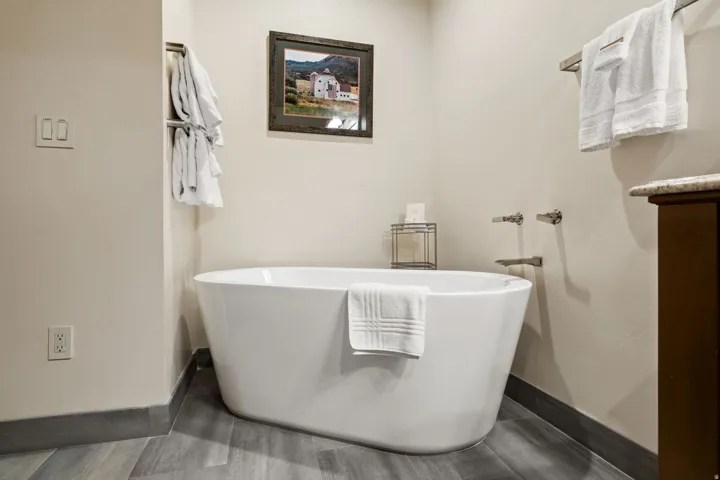 Freestanding soaking tub with wall-mounted fixtures