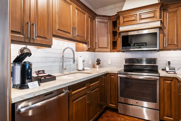 Full kitchen with wood-finish cabinetry, stainless steel appliances, and light-toned countertops