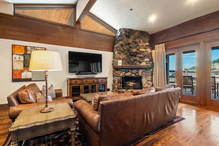 Stone fireplace, wood-finish flooring, wood-beamed ceiling, built-in media console, exterior access