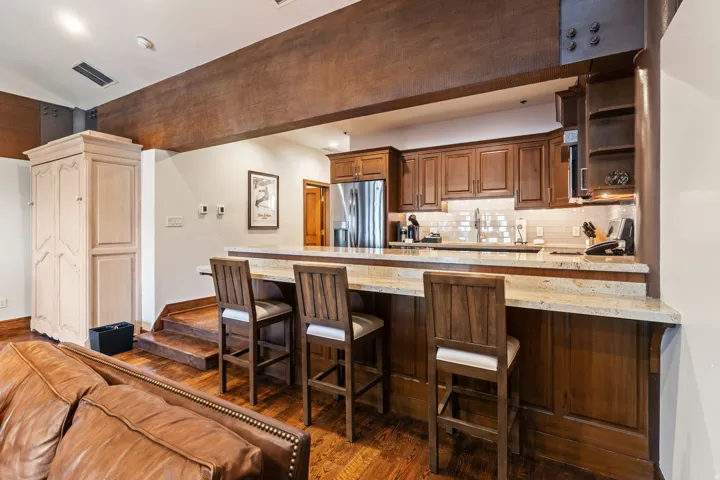 Kitchen featuring wood-finish cabinetry, stainless steel appliances, and a tile backsplash