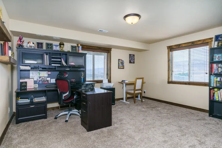 Carpeted room with multiple windows, recessed lighting, and wall-mounted shelving