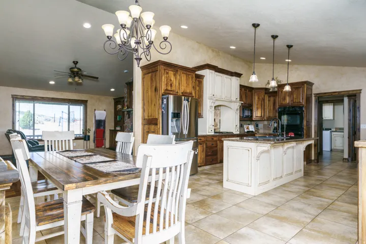 Spacious kitchen with a central island featuring a sink, rich wood cabinetry, and a large window
