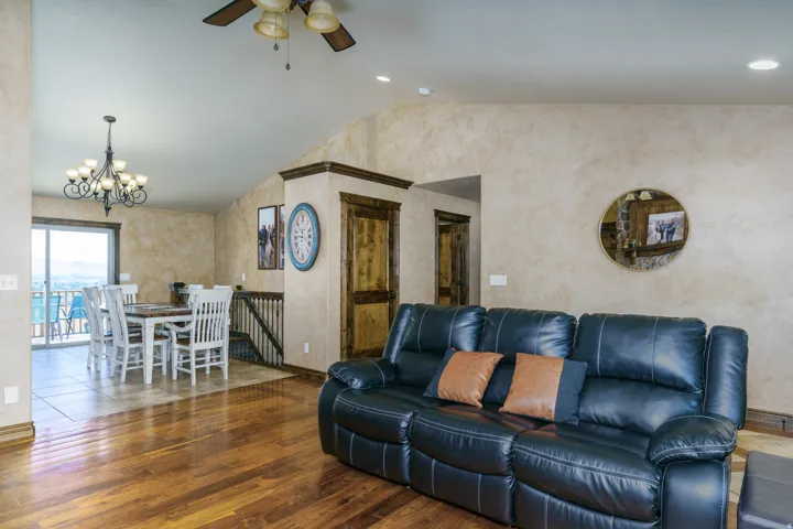 Hardwood flooring, vaulted ceilings, recessed lighting, sliding glass door, and a decorative chandelier
