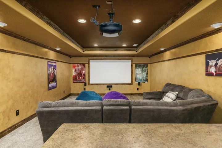 Home theater with projector, recessed lighting, and wall-mounted speakers