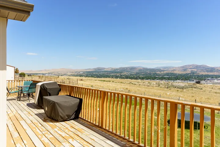 Expansive outdoor deck with a wooden railing and a wide-open landscape