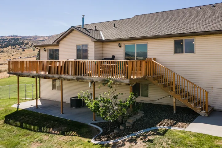 Expansive rear deck with wood railing and stairs