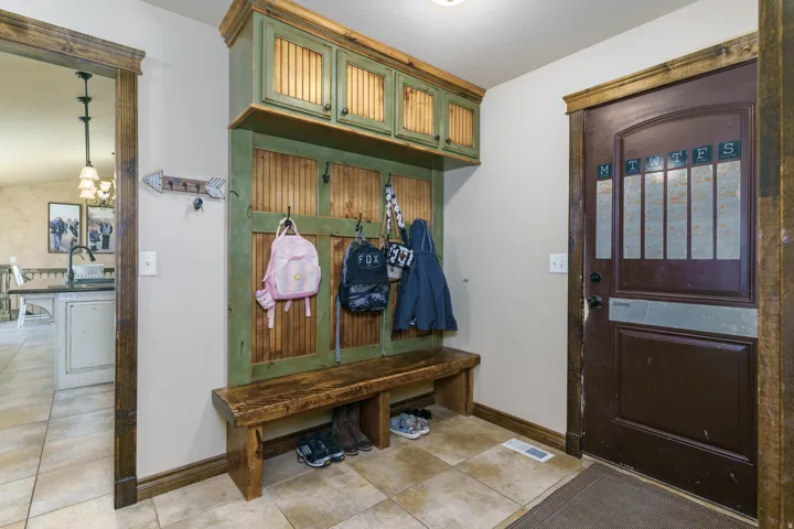 Built-in mudroom bench with storage cabinetry and hooks