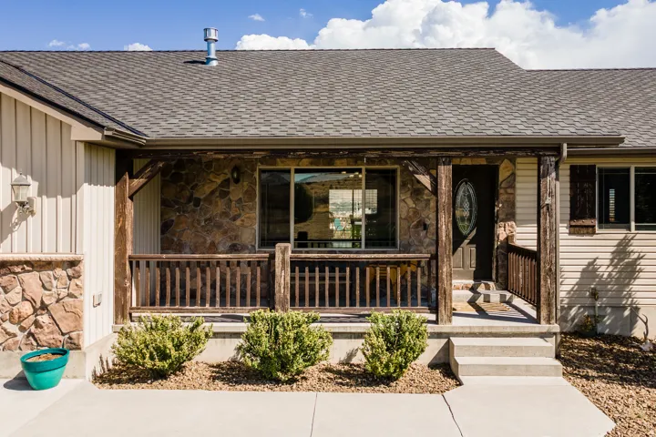 Stone accent siding with a covered front porch featuring wood posts and railing