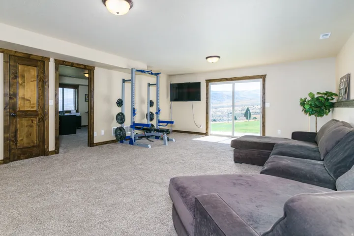 Carpeted room with recessed lighting, a wood-trimmed doorway, and a sliding glass door