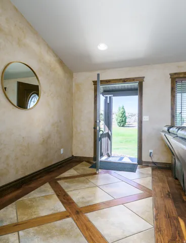 Entryway featuring patterned tile and wood-finish flooring
