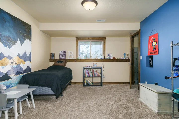 Neutral wall paint, plush carpet flooring, wood-framed window, flush mount ceiling light, and wood-finish door frame