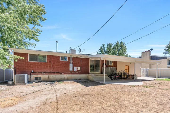 Brick exterior, covered patio, sliding glass door, and fenced perimeter