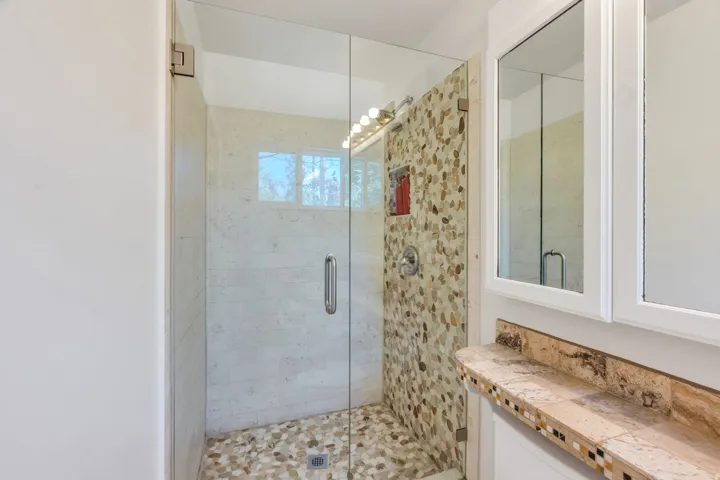 Master Bath Glass-enclosed shower with pebble-style flooring and wall tiling