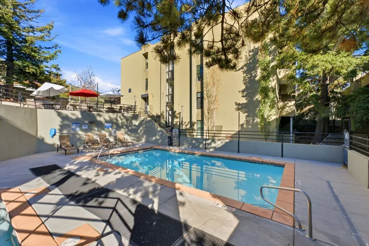 Outdoor swimming pool with integrated spa and surrounding concrete decking