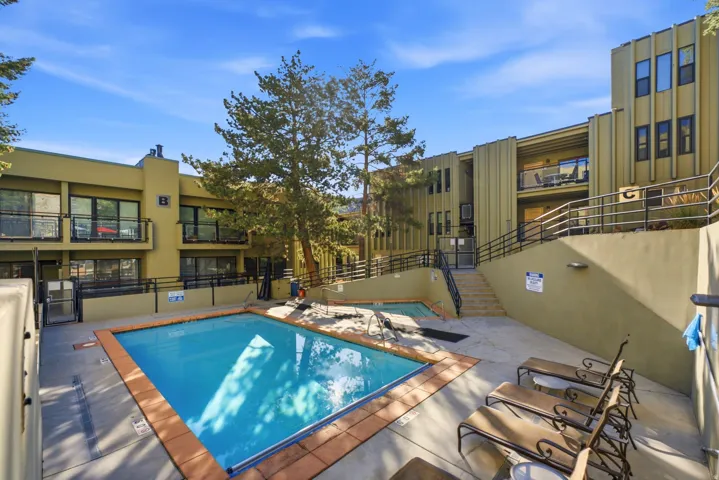Community pool with a tiled edge, surrounding patio, and adjacent spa