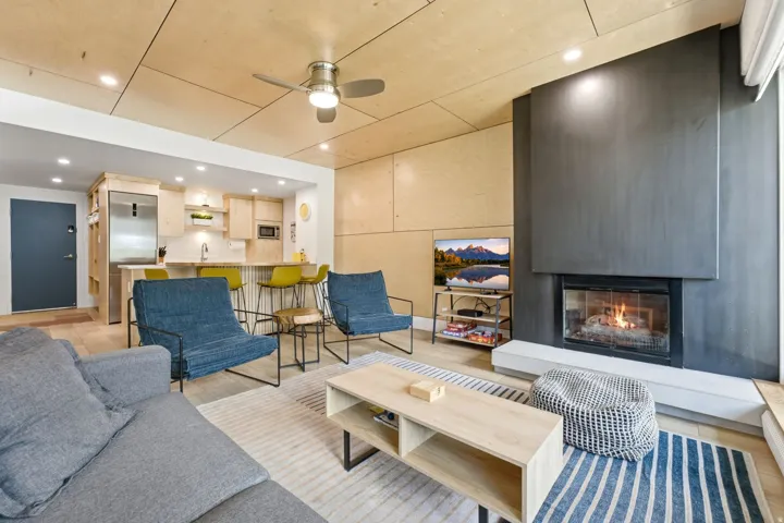 Open-concept living area with a built-in fireplace, recessed lighting, and a ceiling fan