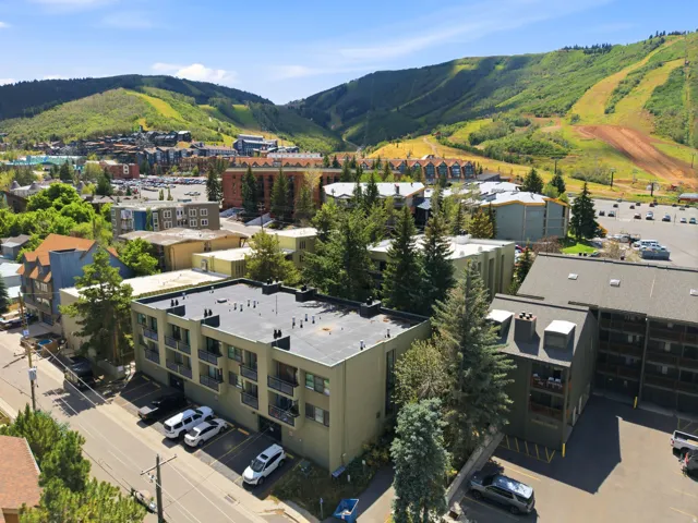 Multi-story building, individual balconies, and a ski mountain backdrop