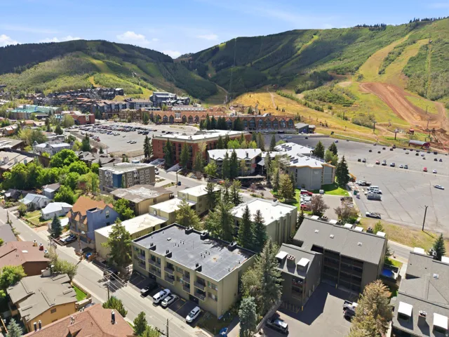 Mountain backdrop, urban landscape, varied architecture, tree-lined streets, parking areas