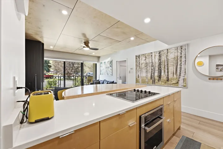 Integrated kitchen with a built-in cooktop, oven, and wood-finish cabinetry. Open concept area