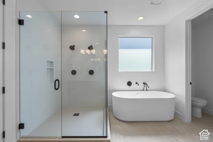 Glass-enclosed shower with matte black fixtures, built-in recessed shelving, and white tile