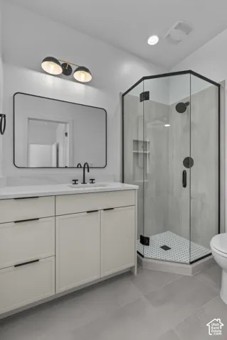 White vanity with black hardware, white countertop, and rectangular mirror