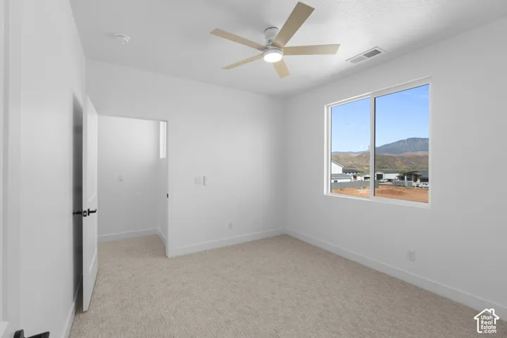 Carpeted flooring, white walls, and a window with mountain scenery