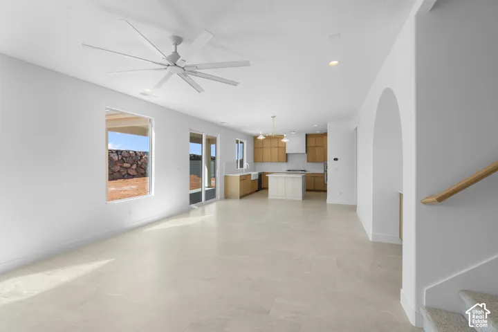 Open-concept living space featuring light-toned flooring, a modern ceiling fan, and recessed lighting