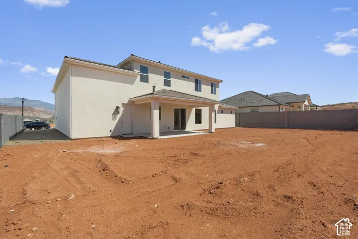 Rear exterior featuring a covered patio, sliding glass door, and stucco siding