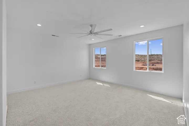 Recessed ceiling lighting, a modern ceiling fan, two large windows, and wall-to-wall carpeting