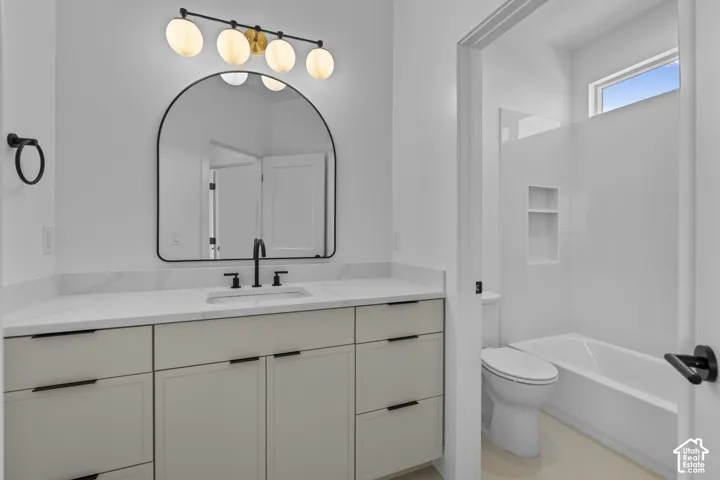 White vanity with a stone countertop and integrated sink, featuring a matte black faucet