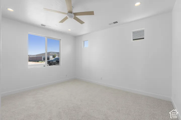 Recessed lighting, wood-finish ceiling fan, and carpeted flooring