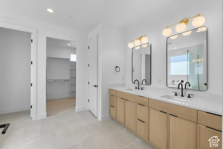 Dual vanity with light wood-finish cabinetry and white countertops