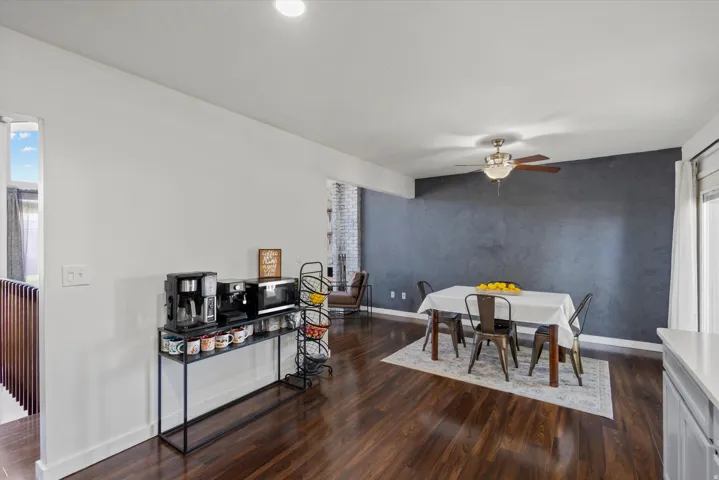 Wood-finish flooring throughout, complemented by a contemporary dark accent wall