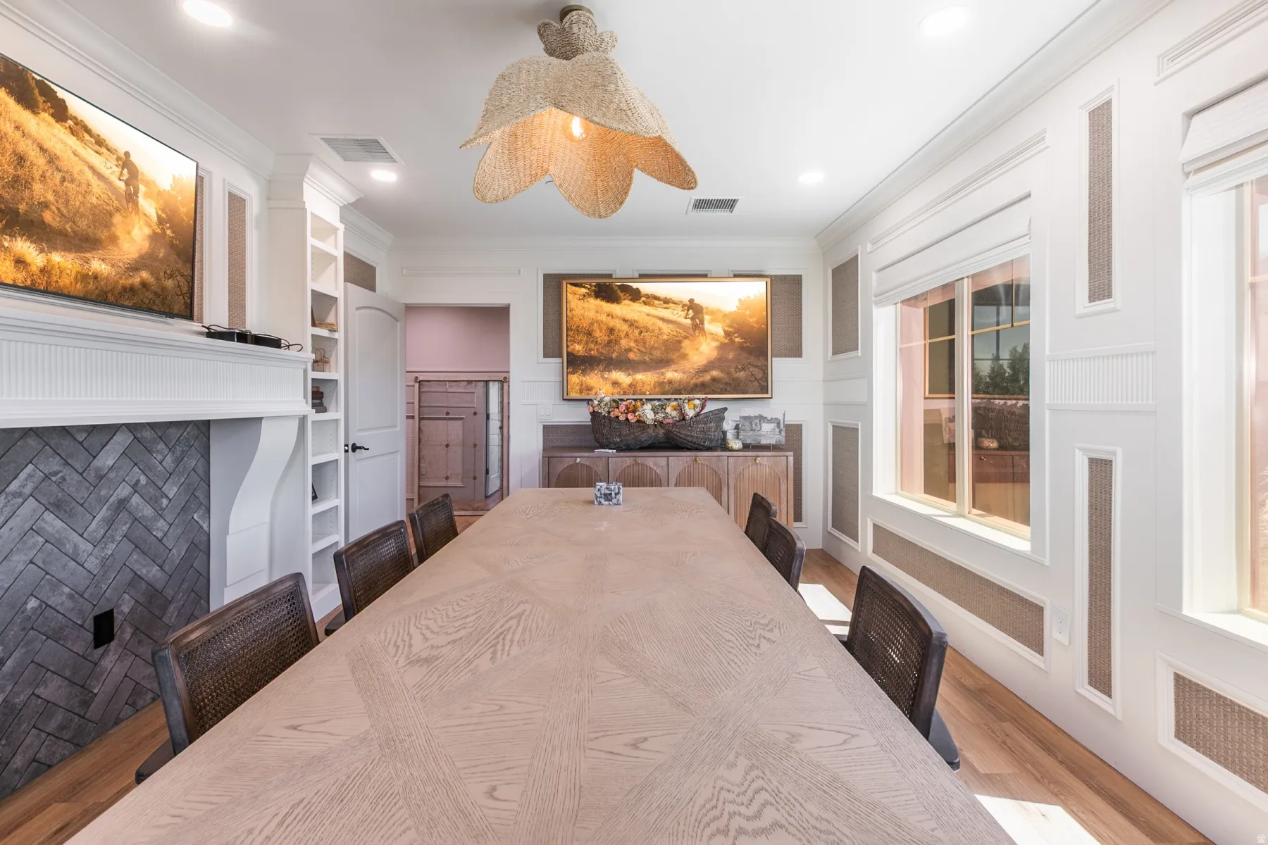 Herringbone brick fireplace, built-in shelving, decorative wall paneling, wood-finish flooring, and recessed lighting