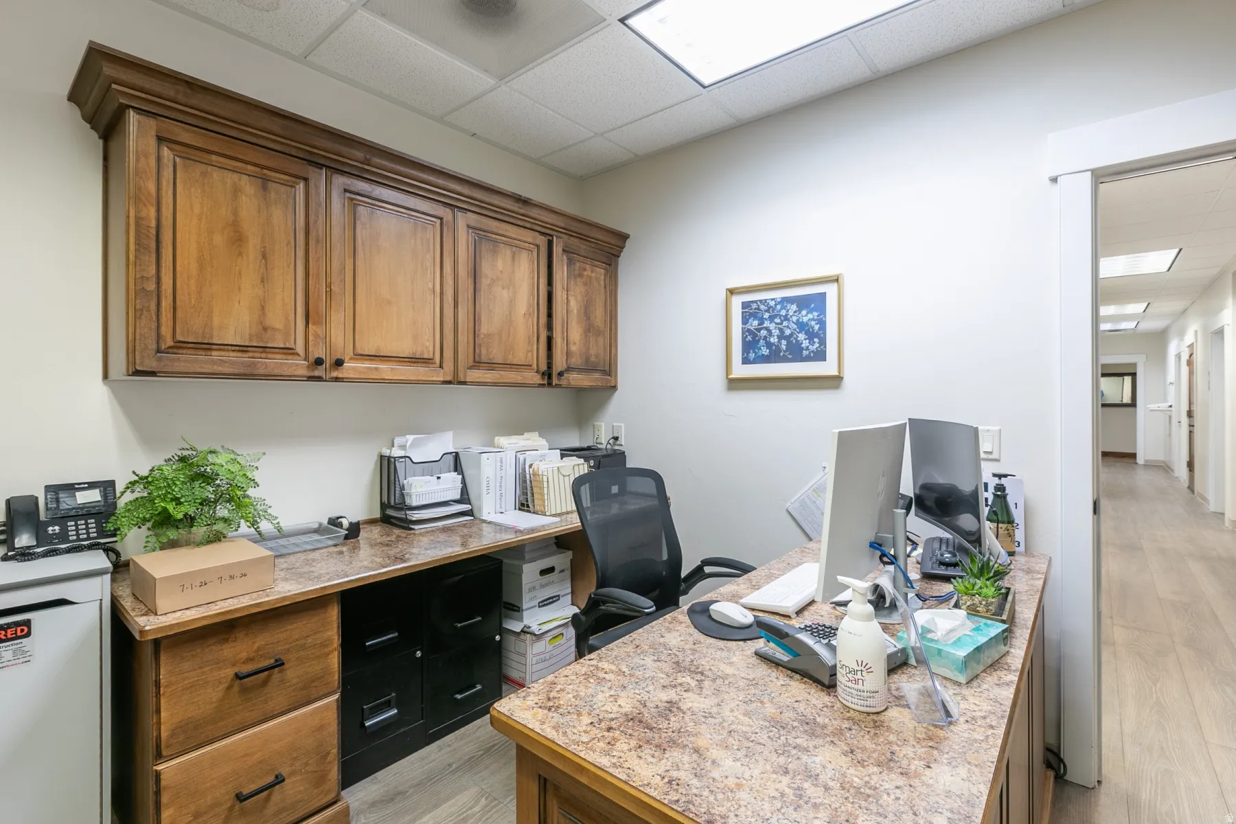 Wood-finish cabinetry and built-in desk with a stone-finish countertop