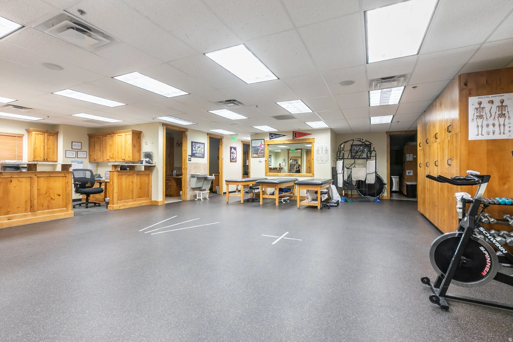Spacious room featuring resilient flooring, extensive built-in wooden cabinetry, recessed lighting, and integrated wall mirrors